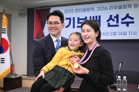 올림픽 양궁 금메달리스트 기보배가 14일 서울 중구 프레스센터에서 열린 은퇴 기자회견에서 남편 성민수씨와 딸 제인양과 기념촬영을 하고 있다. 2024.2.14 홍윤기 기자