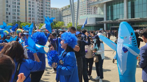 더불어민주당의 21대 대선 후보자 호남권 합동연설회가 열린 26일 전남 광주 김대중컨벤션센터 앞에 옷, 가발, 인형탈, 바람개비 등 각자 파란색 아이템으로 꾸민 민주당 당원들이 춤을 추며 축제 분위기를 즐기고 있다. 광주 곽소영 기자