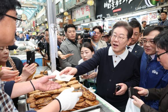 지역화폐 사용하는 이재명 후보 - 이재명(가운데) 더불어민주당 이재명 대선 후보가 ‘골목골목 경청 투어’ : 단양팔경 편‘에 나선 4일 충북 단양군 단양구경시장에서 떡갈비를 사 먹으면서 지역화폐를 사용하고 있다. 2025.5.4