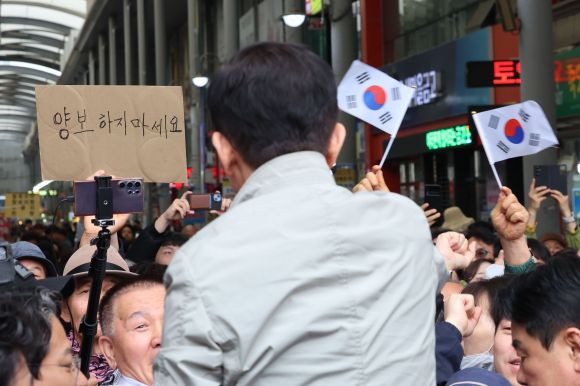 ‘양보하지 마세요’ - 김문수 국민의힘 대선 후보가 6일 경북 포항시 죽도시장을 방문해 시민들에게 인사하고 있다.뒤로 양보하지 마세요란 글자가 보인다. 2025.05.06. 뉴시스