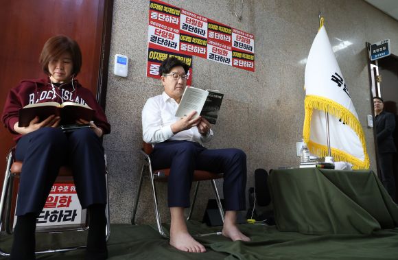 당 대선 후보 단일화를 촉구하며 단식 농성에 돌입한 권성동(오른쪽) 국민의힘 원내대표와 김미애 의원이 8일 오전 서울 여의도 국회 원내대표실 앞에서 책을 읽고 있다. 2025.5.8 뉴시스