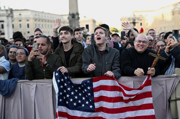 8일(현지시간) 프란치스코 교황을 이을 제267대 교황에 선출된 미국의 로버트 프랜시스 프레보스트(69) 추기경이 바티칸 성 베드로 대성전 발코니에 모습을 드러내자 성조기를 든 신자들이 환호하고 있다. 2025.5.8 바티칸 로이터 연합뉴스