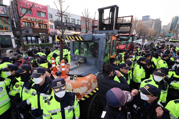 트랙터 둘러싼 경찰 - 지난 3월 서울 종로구 자하문로에서 경찰들이 전국농민회총연맹(전농) 소속 트랙터를 둘러싸고 있는 가운데 시민단체 회원들과 대치하고 있다.  연합뉴스