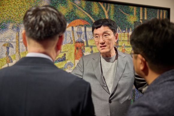 조세현 중구문화재단 사장이 지난달 21일 충무아트센터 갤러리에서 열린 ‘더 글로리어스 월드’ 전시 관련 기자간담회에서 관계자들과 작품에 대한 얘기를 나누고 있다.﻿ 중구문화재단 제공