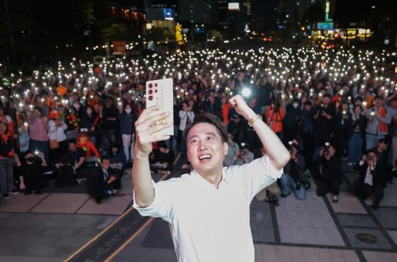 이준석 개혁신당 대선 후보가 공식 선거운동이 시작된 12일 서울 종로구 청계광장에서 열린 출정식에서 자신의 휴대전화로 지지자들과 함께 기념사진을 찍고 있다. 연합뉴스