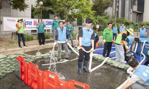 박희영(왼쪽 두 번째) 서울 용산구청장이 지난 14일 ‘2025년 풍수해 대비 종합훈련’이 실시된 원효빗물펌프장에서 임시 물막이판 설치 시연을 지휘하고 있다. 용산구 제공