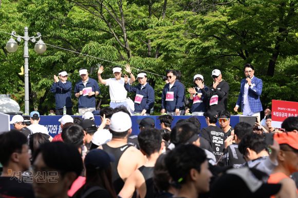 대회에 참석한 김태균(왼쪽부터) 서울신문 콘텐츠본부장, 김성수 서울신문 사장, 오세훈 서울시장, 김철수 대한적십자사 회장, 박용수 인사혁신처 차장, 안미현 서울신문 마케팅본부장, 마라토너 이봉주 선수가 손을 흔들고 있다.  홍윤기 기자