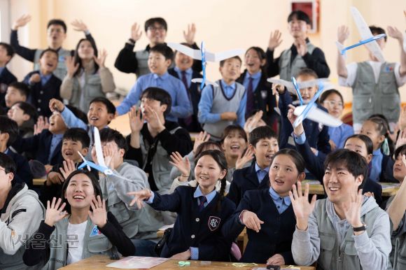 대한항공·아시아나, 몽골서 항공공학 체험 수업 - 대한항공과 아시아나항공 임직원들이 21일 몽골 울란바토르의 군갈루타이 국립학교에서 항공공학 체험 수업을 진행하고 있다. 현지 학생들은 임직원들과 함께 비행기 모형을 만들고 날리며 비행 원리를 배웠다. 울란바토르 홍윤기 기자