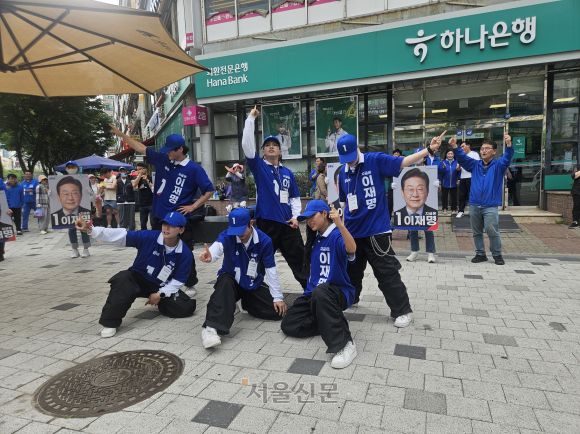 더불어민주당 2030 청년 선거운동원인 시너지유세단이 21일 경기 광명시의 한 인도에서 ‘기호 1번’ 손동작을 취하며 선거유세 무대를 하고 있다. 박상연 기자