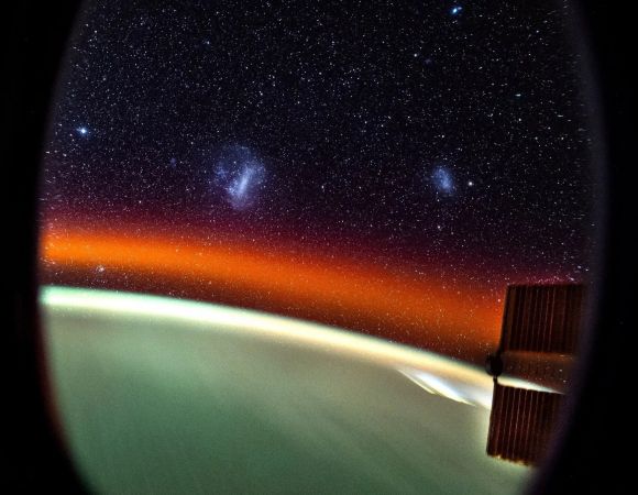 우주비행사 돈 페티트가 촬영한 지구와 마젤란은하. 붉은빛의 정체는 대기광(大氣光)이며 우주 저 멀리 흰색으로 뭉쳐진 두 개의 천체는 각각 대마젤란은하(사진 왼쪽)와 소마젤란은하(오른쪽)다.  NASA/Don Pettit