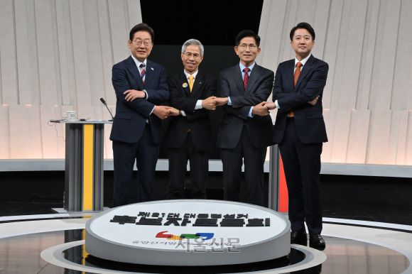 이재명 더불어민주당(왼쪽부터)·권영국 민주노동당·김문수 국민의힘·이준석 개혁신당 대선 후보가 27일 서울 마포구 상암동 MBC 스튜디오에서 진행된 3차 TV 토론회에 앞서 손을 맞잡고 사진을 찍고 있다. 2025.5.27 국회사진기자단