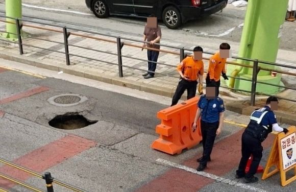 인천 서구 가정동의 한 도로에서 싱크홀이 발생해 경찰 등이 차량을 통제하고 있다. 연합뉴스