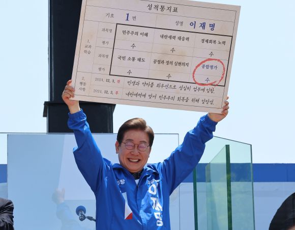 더불어민주당 이재명 대선 후보가 선거를 이틀 앞두고 ‘험지 공략’에 나선 1일 고향인 경북 안동시의 웅부공원에서 열린 유세에서 성적표를 들어 보이고 있다. 2025.6.1 연합뉴스