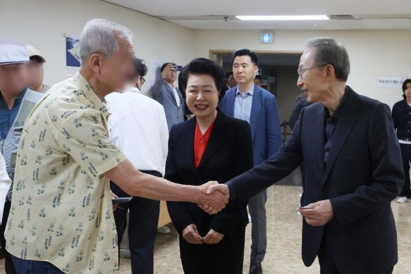 유권자와 인사 나누는 이명박 전 대통령 - 이명박 전 대통령이 제21대 대통령선거 투표일인 3일 서울 강남구 국민연금공단 서울남부지역본부에 마련된 논현1동제3투표소에서 유권자와 악수를 나누고 있다. 가운데는 이 전 대통령 부인 김윤옥 여사. 2025.6.3 연합뉴스