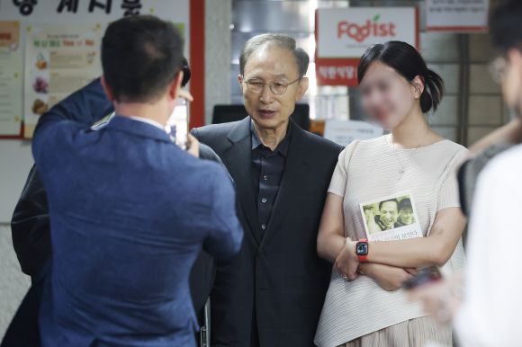 지지자들과 기념촬영하는 이명박 전 대통령 - 이명박 전 대통령이 제21대 대통령선거 투표일인 3일 서울 강남구 국민연금공단 서울남부지역본부에 마련된 논현1동제3투표소에서 투표에 앞서 이 전 대통령의 저서 ‘절망이라지만 나는 희망이 보인다’를 들고 온 지지자들과 함께 기념촬영하고 있다. 2025.6.3 연합뉴스