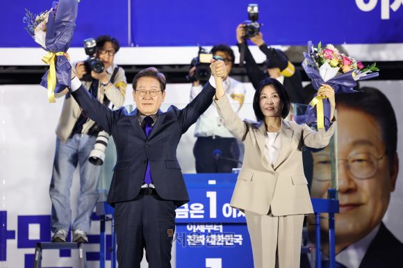 이재명 대통령와 김혜경 여사가 4일 오전 서울 여의도 국회 앞에서 열린 국민 개표방송 행사에서 꽃다발을 받은 뒤 시민들을 향해 인사하고 있다. 2025.6.4 홍윤기기자