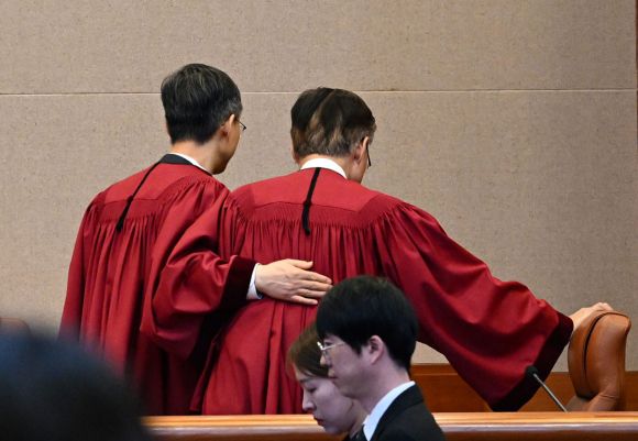 지난해 12·3 비상계엄 이후 3일의 21대 대통령 선거까지 183일이 숨가쁘게 지나갔다. 지난 4월 4일 문형배(왼쪽) 당시 헌법재판소장 직무대행이 서울 종로구 헌법재판소 대심판정에서 윤석열 전 대통령에게 파면을 선고한 뒤 김형두 헌법재판관과 함께 법정을 나가고 있는 모습. 사진공동취재단