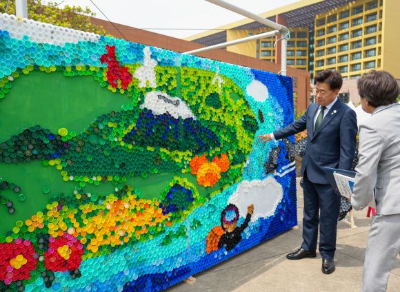 오영훈 제주도지사가 4일 제주국제컨벤션센터 야외광장에서 열린 ‘2025 환경 한마당 축제’행사의 일환으로 폐플라스틱 병뚜껑 활용 업사이클 벽화 작업 프로젝트에 동참한 뒤 벽화를 감상하고 있다. 제주도 제공