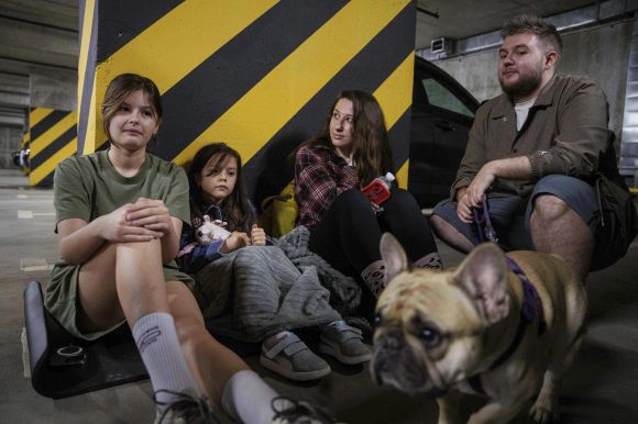 2025년 6월 6일(현지시간) 우크라이나 수도 키이우의 한 아파트 지하 주차장에 일가족이 대피해 있다. 이날 러시아군은 이 도시에 대규모 공습을 감했다. AP 연합뉴스