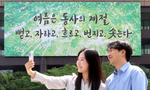 ‘나는 여름이 좋다’ - 9일 서울 종로구 교보생명 건물 외벽의 광화문글판에 여름맞이 새단장으로 이재무 시인의 시 ‘나는 여름이 좋다’에서 발췌한 글귀 “여름은 동사의 계절. 뻗고, 자라고, 흐르고, 번지고, 솟는다”가 게시돼 있다. 광화문글판은 시민 공모를 통해 계절마다 새 문구와 디자인을 선보인다. 뉴시스