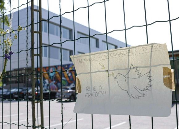 지난 12일 오스트리아 남동부 그라츠의 한 고등학교 앞에 루마니아어(위)와 독일어로 ‘신의 평화가 함께하길’이라고 적힌 애도의 표현이 걸려 있다. 그라츠 AFP 연합뉴스