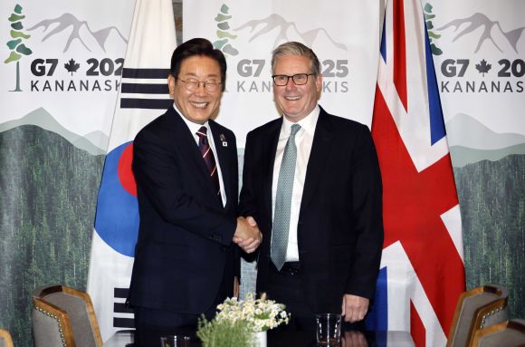 이재명 대통령, 한-영 정상회담 - 이재명 대통령이 17일(현지시간) 캐나다 앨버타주 캐내내스키스 주요 7개국(G7) 정상회의장에서 키어 스타머 영국 총리와 한영 정상회담 전 악수하고 있다.  연합뉴스