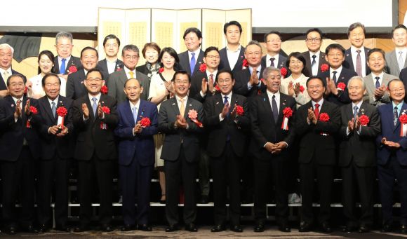 한일 정상회담 다음날… 수교 60주년 행사에 전현직 日총리 3명 깜짝 등장 - 오는 22일 한일이 기본조약을 체결한 지 60주년을 맞는 가운데 19일 뉴오타니호텔 도쿄에서 열린 ‘한일 국교정상화 60주년 기념식’에서 참석자들이 기념촬영을 하고 있다. 이날 행사에는 이시바 시게루 일본 총리가 ‘깜짝’ 등장해 한일 양국의 교류를 강조했다. 첫줄 왼쪽 세 번째부터 주호영 한일의원연맹 회장, 스가 히데요시 전 총리, 박철희 주일한국대사, 기시다 후미오 전 총리, 이와야 다케시 외무상, 윤재옥 국민의힘 의원. 도쿄 연합뉴스