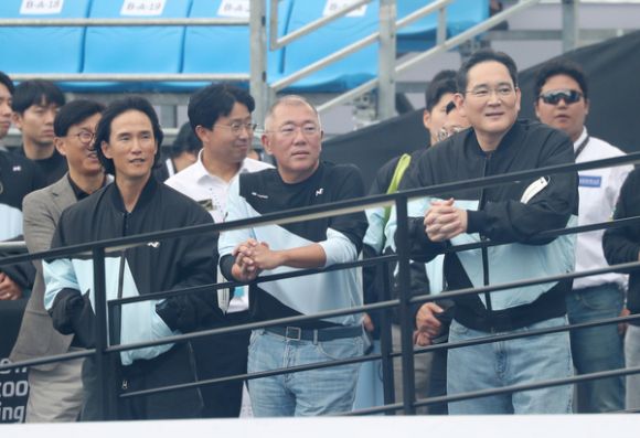 조현범(앞줄 왼쪽) 한국앤컴퍼니그룹 회장과 정의선(가운데) 현대차그룹 회장, 이재용 삼성전자 회장이 지난해 10월 27일 경기 용인 스피드웨이에서 열린 ‘현대 N×토요타 가주 레이싱 페스티벌’ 행사장에서 나란히 ‘현대 N’ 유니폼을 입은 채 레이싱 현장을 지켜보고 있다. 뉴스1