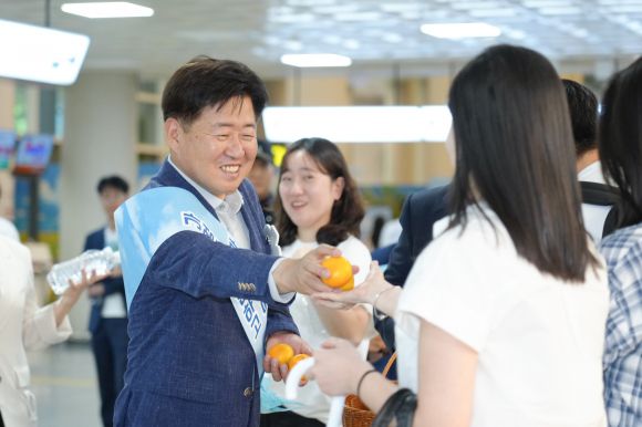 오영훈 제주지사가  지난 21일 오후 제주국제공항 1층에서 열린 ‘가성비에 반하고, 가심비에 머무는 제주’를 주제로 관광객 환영행사에서 제주를 방문한 관광객에게 귤을 나눠주고 있다. 제주도 제공
