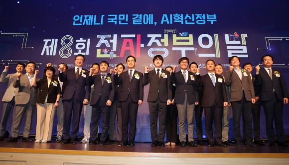 하정우 대통령실 AI미래기획수석(앞줄 오른쪽 다섯 번째)과 김민재 행정안전부 차관(앞줄 오른쪽 여섯 번째)이 25일 정부세종컨벤션센터에서 열린 제8회 전자정부의 날 행사에서 주요 참석자들과 함께 파이팅을 외치고 있다. 연합뉴스