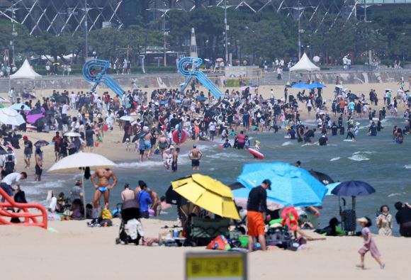 해운대해수욕장 피서객 북적 - 전국 대부분 지역에 폭염특보가 내려진 29일 오후 부산 해운대해수욕장에서 피서객들이 물놀이하며 더위를 식히고 있다. 기상청은 30일 아침 최저기온이 20∼26도, 낮 최고기온은 27∼35도로 평년보다 높겠다고 예보했다. 부산 연합뉴스