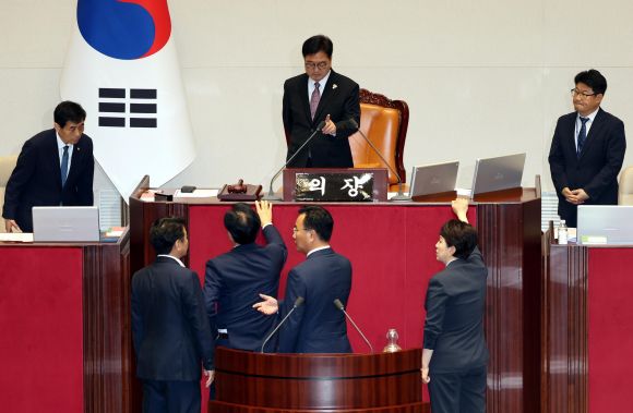 ‘본회의 지연에 항의하는 국민의힘’ - 송언석(아래 왼쪽 두번째) 국민의힘 비상대책위원장 겸 원내대표와 유상범 원내운영수석, 김은혜 원내정책수석이 4일 오후 서울 여의도 국회 본회의장에서 더불어민주당의 내부사정으로 본회의가 지연되는 것에 대해 우원식 국회의장에게 항의를 하고 있다. 이에 문진석(아래 왼쪽) 민주당 원내운영수석이 양해를 구하고 있다.  뉴시스