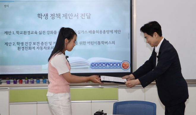 화순오성초 한 학생이 지구의 미래를 지키기 위한 약속과 정책 제안서를 김대중 전남교육감에게 전달하고 있다.