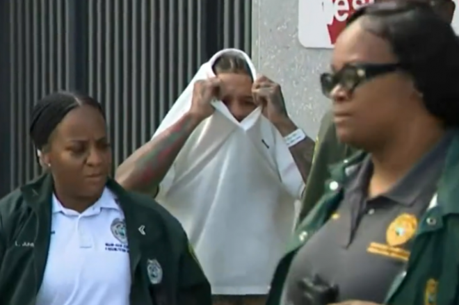 두 아이의 엄마인 전 여자친구를 폭행한 혐의로 11일(현지시간) 체포돼 조사를 받은 세계복싱협회(WBA) 라이트급 세계챔피언 저본타 데이비스가 옷으로 얼굴을 가린 채 터너길포드나이트 교정센터를 나서고 있다. 미국 CBS 보도화면 캡처