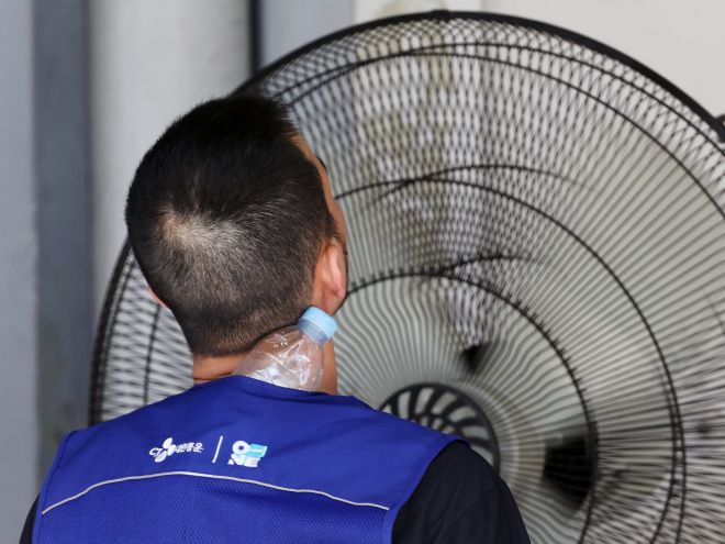 선풍기 바람과 얼음물로 식히는 폭염 - 연일 폭염이 이어지고 있는 9일 서울 시내 한 택배물류센터에서 노동자가 택배 분류 작업 중 더위를 식히고 있다.  2025.7.9 뉴스1