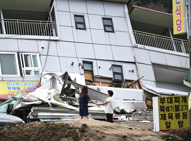 20일 폭우에 휩쓸려 붕괴된 경기 가평 한 건물 앞에서 주민들이 손을 맞잡고 있다. 이날 가평 일대에서는 밤사이 내린 폭우로 산사태와 범람 등이 발생해 2명이 사망하는 등 각종 인명 피해가 속출했다. 이날 가평의 누적 강수량은 오전 9시 30분 기준 197.5mm였다. 2025.7.20 이지훈 기자