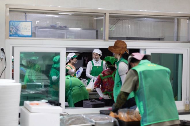 이재명 대통령 부인 김혜경(가운데) 여사가 24일 집중호우로 큰 피해를 본 경기 가평군 백둔리를 찾아 마을회관에서 자원봉사자들과 함께 대민 지원 활동에 나선 군장병 300여명에게 줄 점심 식사 준비를 하고 있다.  대통령실 제공