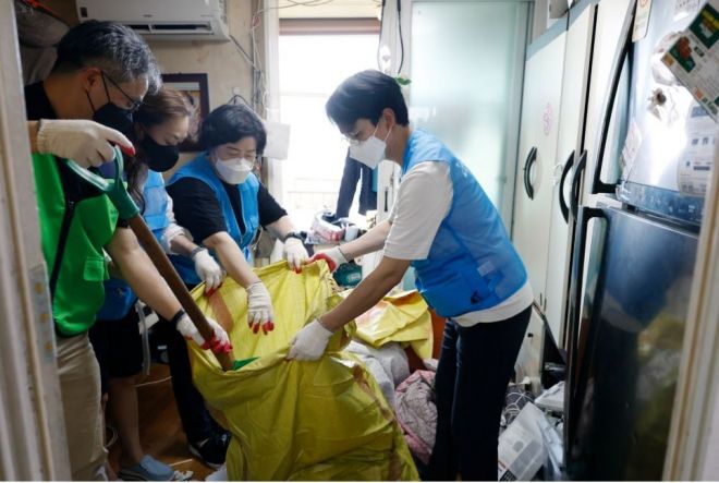 저장강박 의심세대를 청소 중인 서준오 의원(오른쪽)