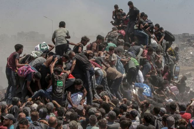 26일(현지시간) 팔레스타인 가자지구 남부 라파에 트럭 두 대가 들어서자 셀 수 없이 많은 가자 주민이 몰려들었다. EPA 연합뉴스