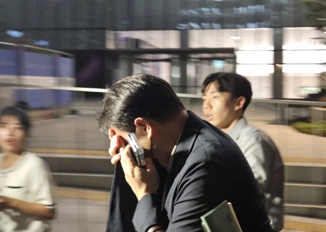 김건희 여사 오빠인 김진우 씨가 28일 김 여사 관련 의혹들을 수사하는 민중기 특별검사팀 사무실이 위치한 서울 종로구 KT광화문빌딩에서 조사를 마친 뒤 얼굴을 가린 채 특검 사무실을 나서고 있다. 김씨는 이른바 ‘양평 공흥지구 개발 특혜 의혹’의 핵심 당사자다. 2025.7.28 연합뉴스