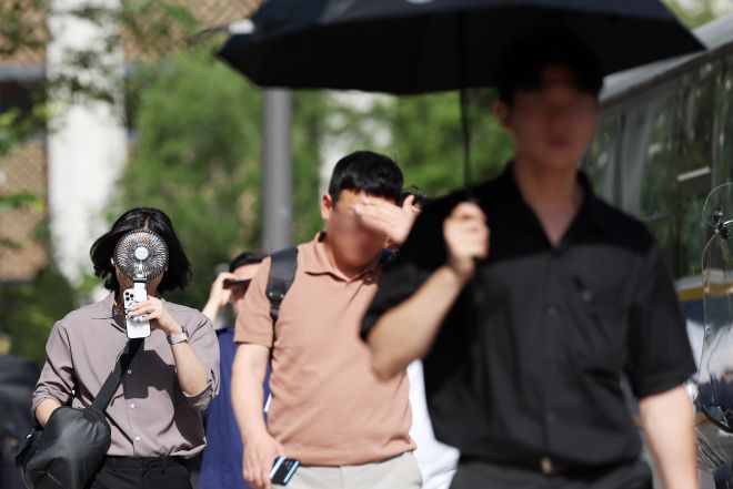 폭염이 계속되는 10일 서울 종로구 거리에서 시민이 선풍기와 양산 등으로 더위를 식히며 이동하고 있다. 2025.07.10. 뉴시스