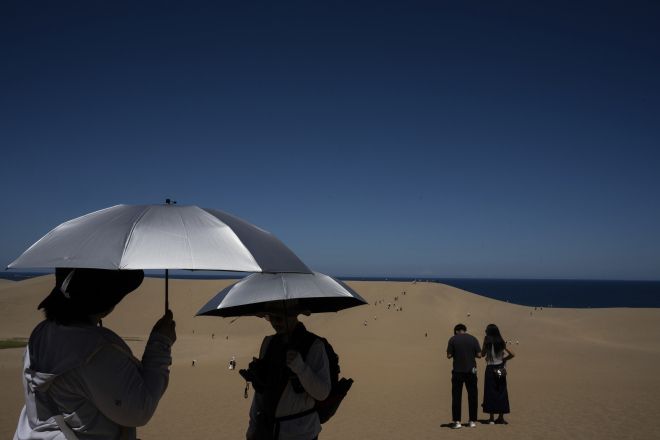 28일 일본 돗토리현 돗토리 사구에서 방문객들이 양산을 쓰고 있다. 2025.7.28 AP 연합뉴스
