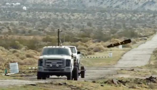 미 공군 훈련장에서 헬파이어 미사일이 표적 차량을 향해 낙하하는 장면. 실험 장비가 장착된 트럭이 표적 차량을 견인하고 있으며, 공중에서 날아든 AGM‑114 헬파이어(Hellfire) 미사일이 곧 충돌하는 순간이 포착됐다. 해당 사진은 미국 국방부 훈련 영상에서 캡처된 것으로, 실제 공대지 미사일 정밀 타격 훈련 장면이다. 출처=미국 국방부 퍼블릭 도메인