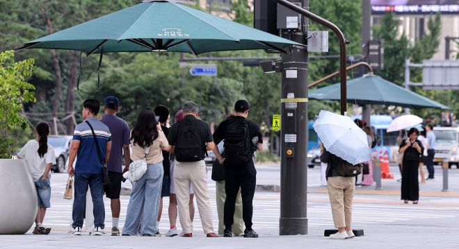 그늘 아니면 양산 - (서울=뉴스1) 박지혜 기자 = 절기상 ‘처서’가 이틀 앞으로 다가왔지만 여전히 찜통 더위가 이어진 21일 오후 서울 광화문네거리에서 시민들이 횡단보도 앞 그늘막 아래 모여 신호를 기다리고 있다.   폭염특보가 해소되기는커녕 폭염경보로 격상되는 지역들이 늘면서, 당분간 무더위는 지속될 전망이다. 2025.8.21/뉴스1