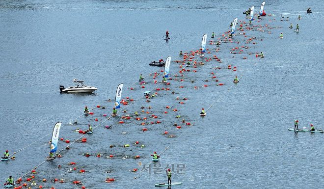 23일 서울 한강 잠실대교 남단 일대에서 열린 2025 한강크로스스위밍챌린지에서 참가자들이 힘껏 헤엄치고 있다. 2025.8.23 오장환 기자