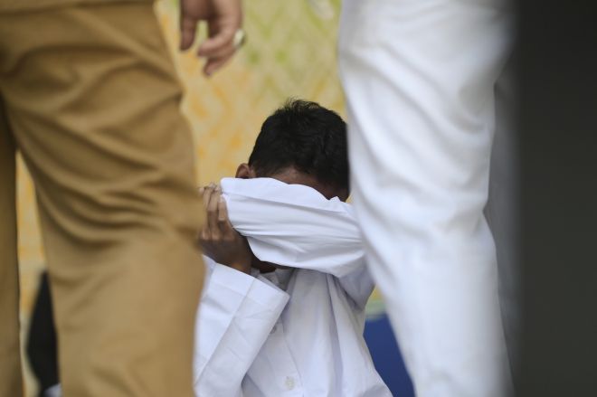공원 화장실에서 다른 남성과 키스해 샤리아(이슬람 율법)를 위반한 혐의로 유죄 판결을 받은 남성이 지난 26일(현지시간) 인도네시아 아체주 반다아체에서 진행된 태형 집행 후 바닥에 앉아 있다. 2025.8.26 AP 연합뉴스