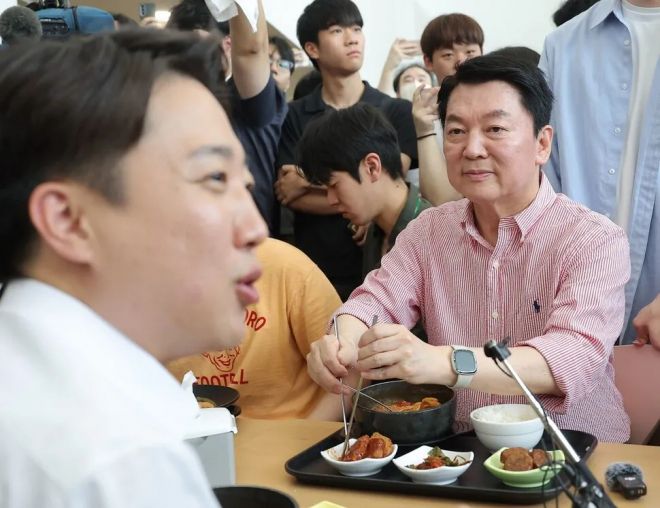 국민의힘 안철수 의원이 21일 경기 성남시 가천대학교 글로벌캠퍼스에서 열린 ‘학식 먹자 이준석’ 행사에 참석한 가운데 학생들과 대화를 나누는 개혁신당 이준석 대선 후보를 바라보고 있다. 연합뉴스