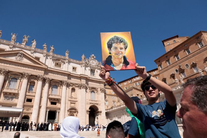 지난 7월 30일(현지시간) 바티칸 성 베드로 광장에서 열린 교황 레오 14세의 일반 알현 때 한 청년이 카를로 아쿠티스의 초상화를 들어 보이고 있다. 카를로는 이달 7일 MZ세대 첫 성인으로 시성된다. 로이터 연합뉴스