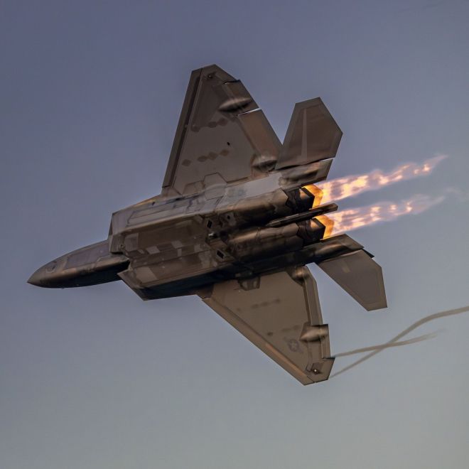 노을빛 하늘을 가르며 애프터버너 화염을 분출하는 F-22 랩터. 미 국방부 제공