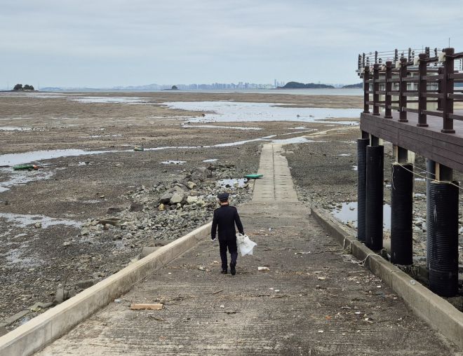 A경위가 ‘사고 지점인 꽃섬 인근에 국화꽃을 두고 오겠다’며 갯벌로 들어가고 있다. 반영윤 기자
